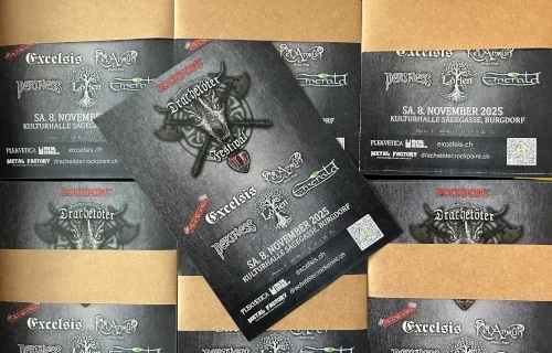 Das Bild zeigt die Flyer des Drachetöter Festival vom 8. November 2025. Einer der Flyer liegt schräg auf den anderen gebundenen Packeten.