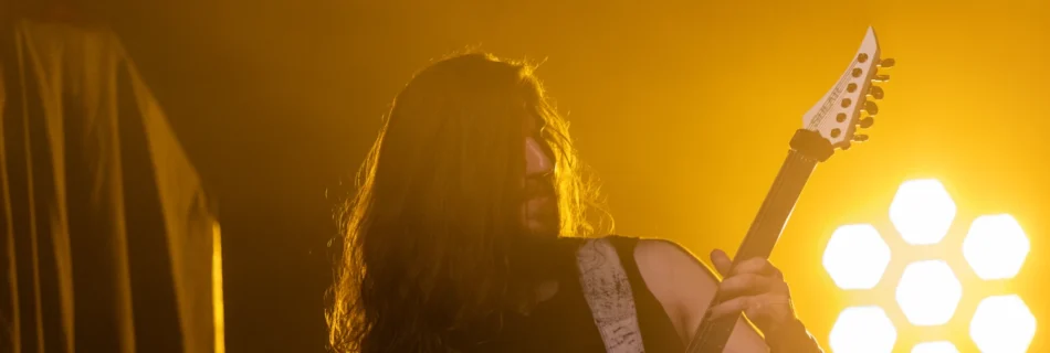 Ein Mann mit Gitarre im Scheinwerferlicht.